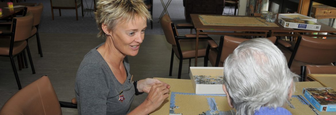 Avonlea Rest Home Manager Anna Looby working on a puzzle with a resident.